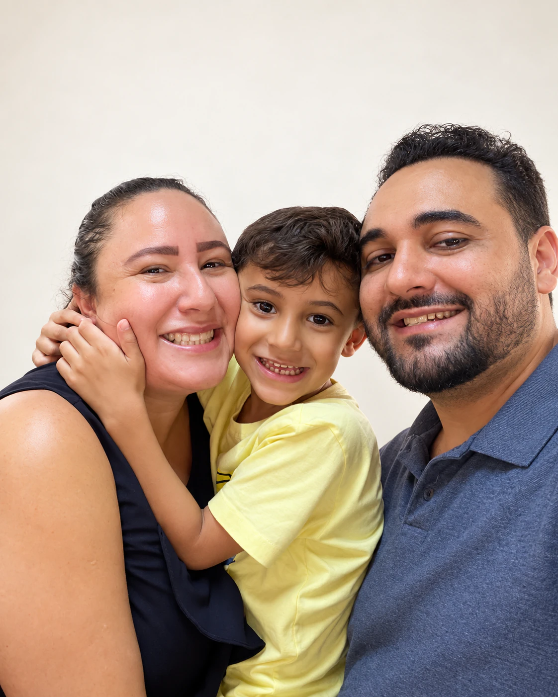 Família sorrindo junta, com a criança abraçando a mãe