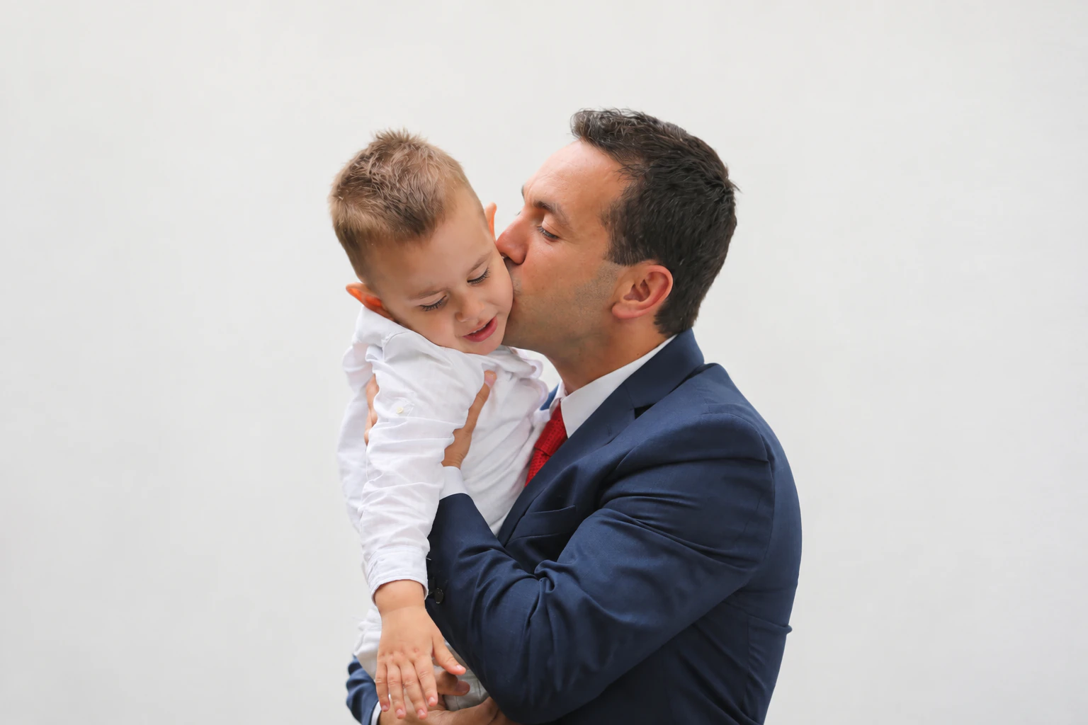 Pai abraçando e beijando o filho