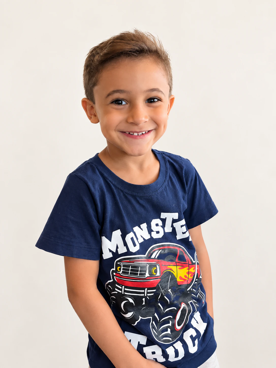 Menino sorrindo com camiseta azul sobre fundo claro